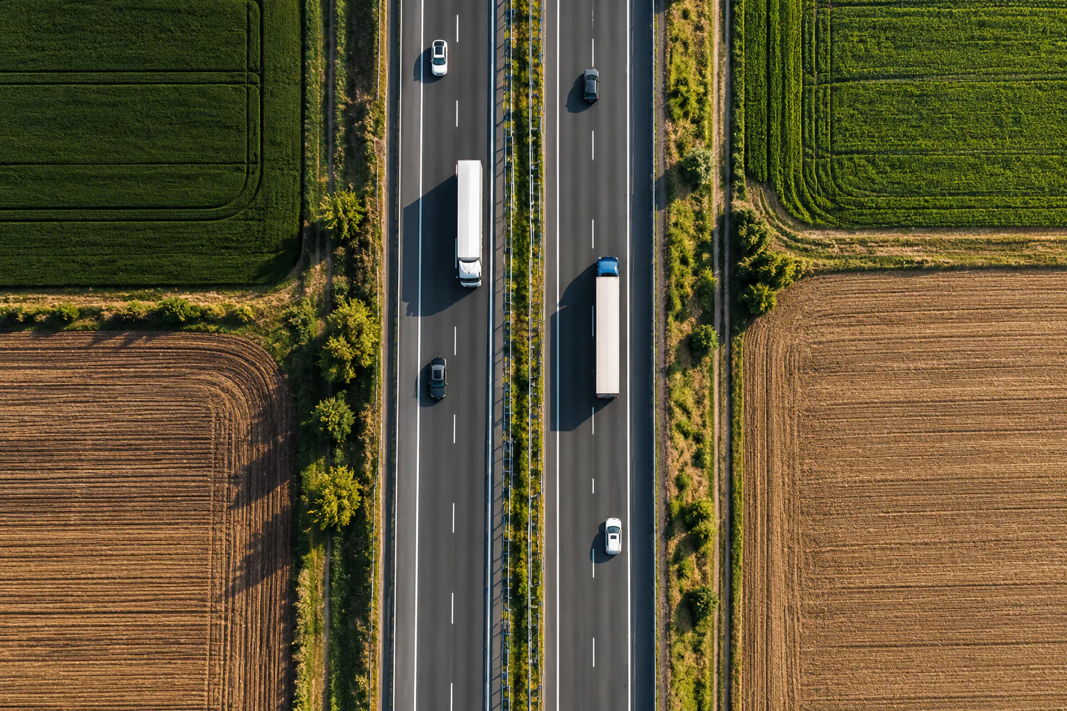 Perspectivă verticală de deasupra autostrăzii, între câmpuri verzi și aurii